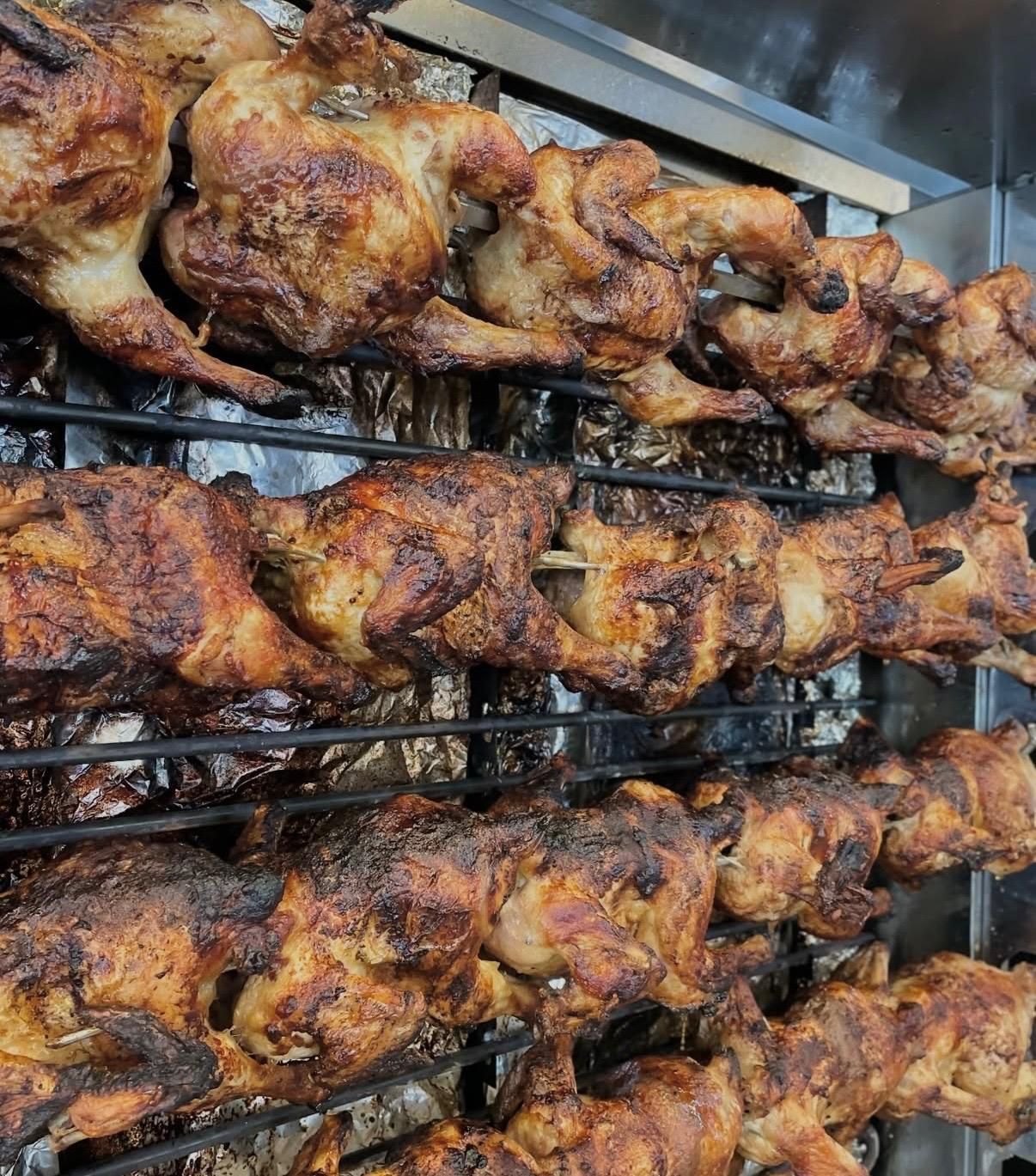 Detalle de los pollos dorados en la parrilla giratoria